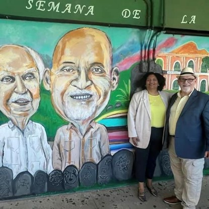 Prof-Rodriguez y acompañante frente a mural