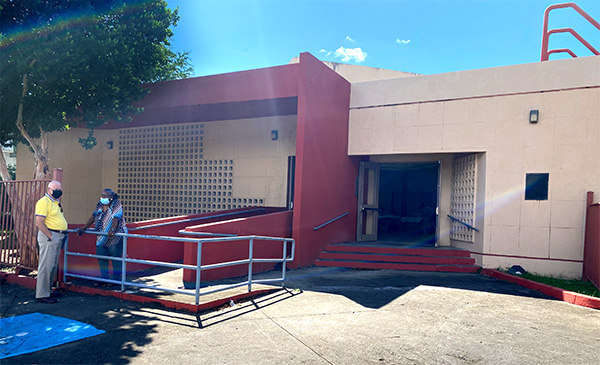 centro comunal entrada con dos personas - community center entrance with two people in front
