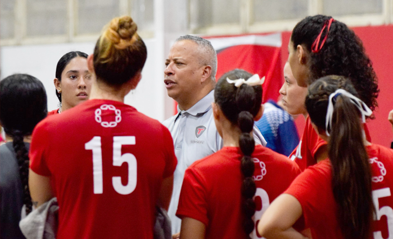 Dirigente don el equipo de voleibol femenino dando instrucciones