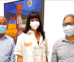 Foto de la doctora Irene Esteves Amador junto a otras dos personas paradas frente a una obra de arte