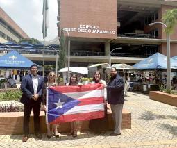 Estudiantes doctorales participan en congreso en Colombia con la bandera de Puerto Rico 