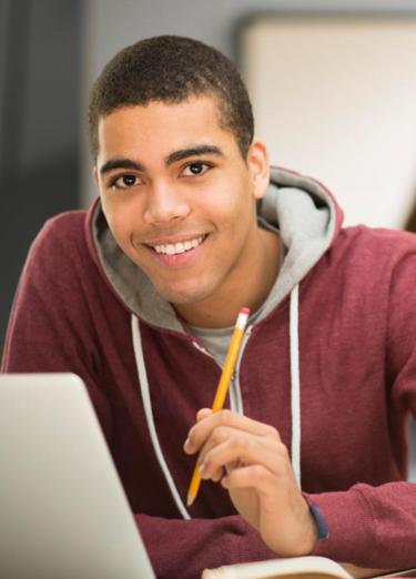 Estudiante sentado en escritorio con su laptop