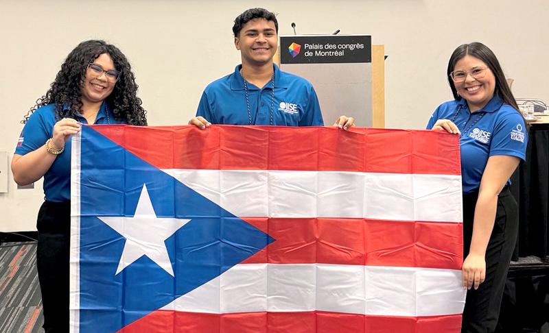 tres estudiantes sosteniendo la bandera de PR