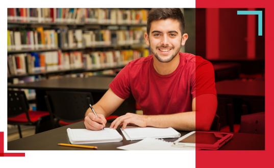 estudiante hombre en biblioteca sonriendo
