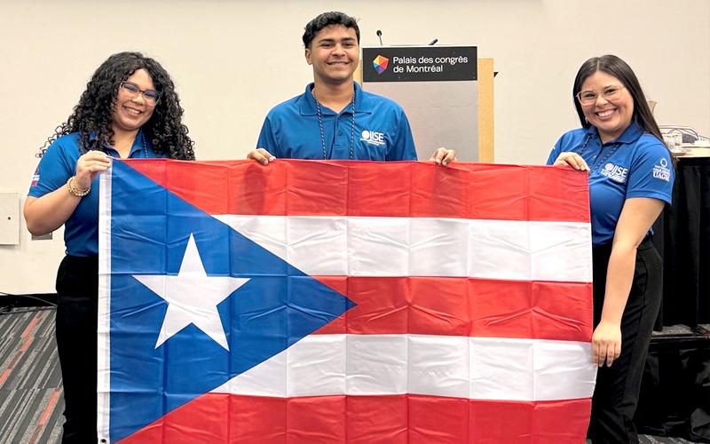 tres estudiantes sosteniendo la bandera de PR
