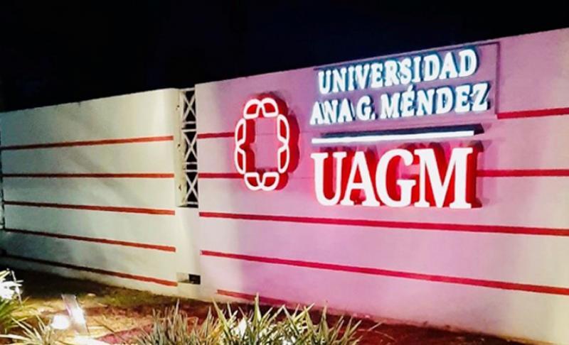 letrero de UAGM iluminado de púrpura