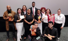 Profesor con estudiantes y el premio de Enactus